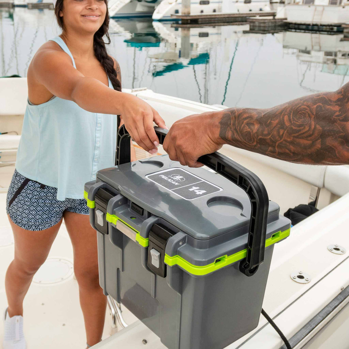 14QT Personal Pelican Cooler being passed to another person by using the retractable handle