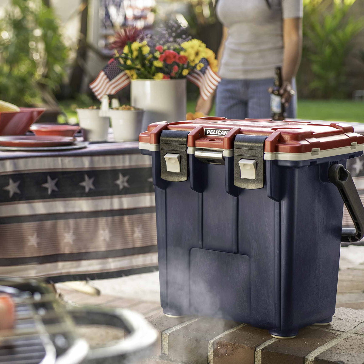 20Q-5-BLURED-WHT 20QT Pelican Elite Cooler being used at an outdoor cookout.