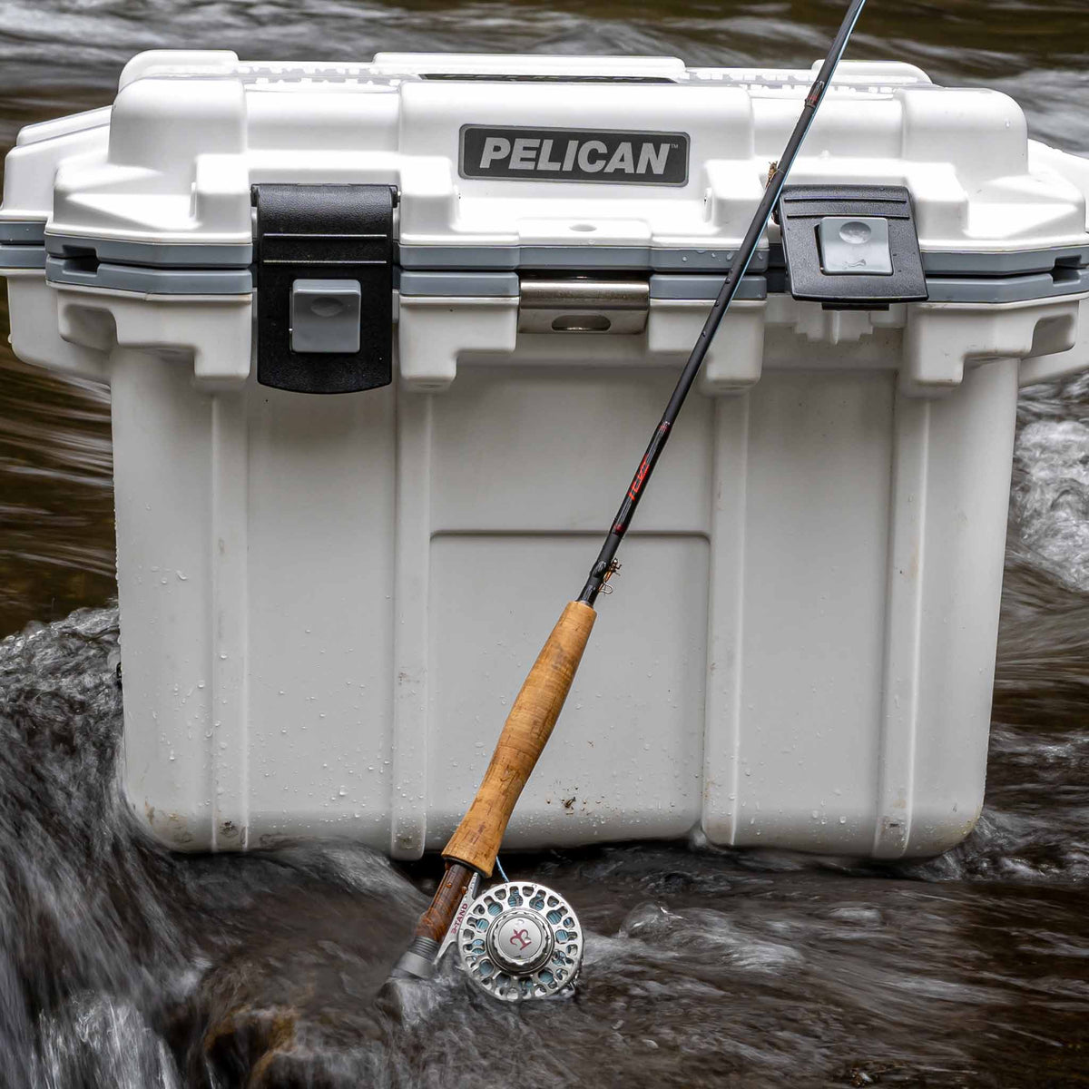 30Q-1-WHTGRY 30QT Pelican Elite Cooler in stream with fishing rod